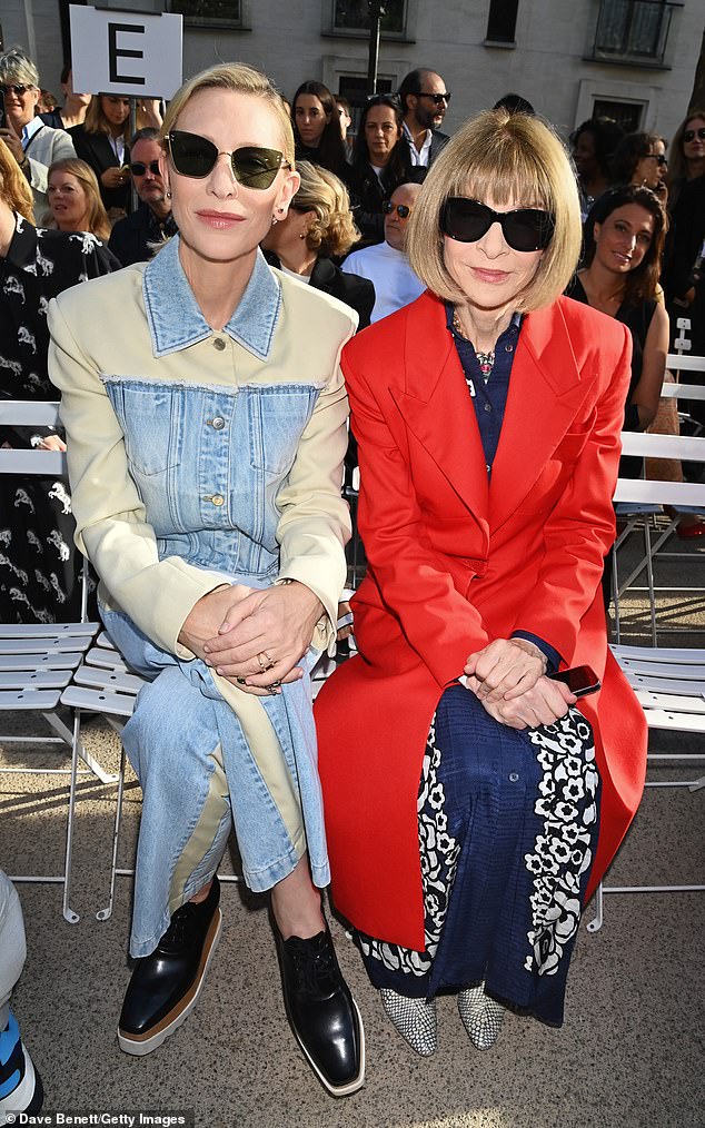 О, моя Анна!  Грозный редактор Vogue была одета в свои фирменные солнцезащитные очки и элегантное красное пальто поверх темно-синего платья, когда она села, чтобы взглянуть своим проницательным взглядом.