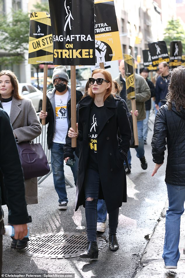 В поддержку дела: Неподалеку Честейн также носил «SAG-AFTRA ON Strike!»  Футболка, когда она высоко подняла плакат с таким же рисунком.  Похоже, она скандировала, подбадривая протестующих, когда шла в ряд с остальными протестующими.
