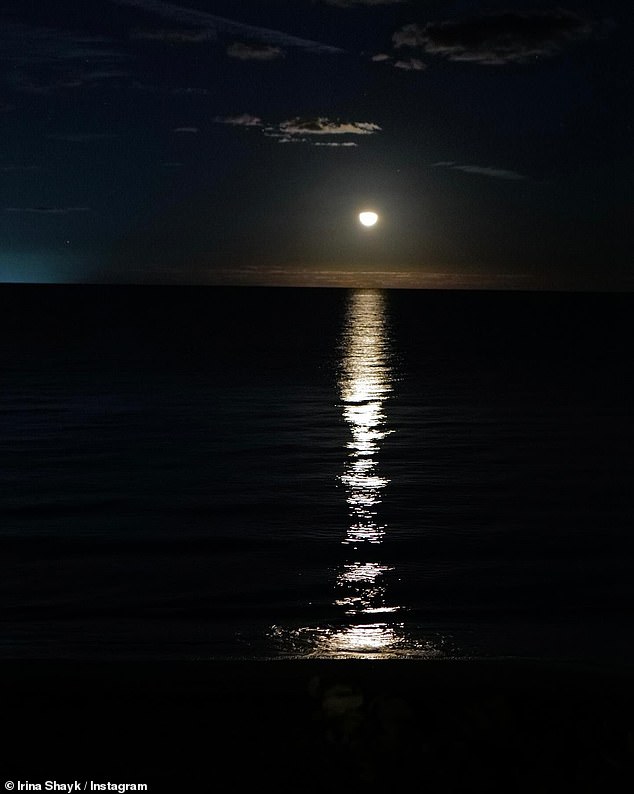 Она сфотографировала луну, отражающуюся от моря.