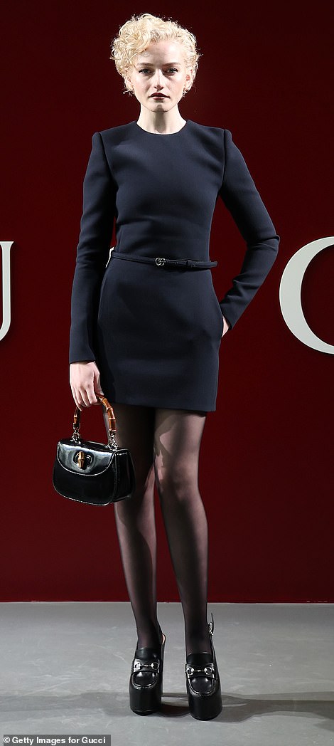 Джулия Гарнер выбрала элегантное мини-платье с поясом Gucci, а образ дополнила колготками и черными лоферами на платформе.