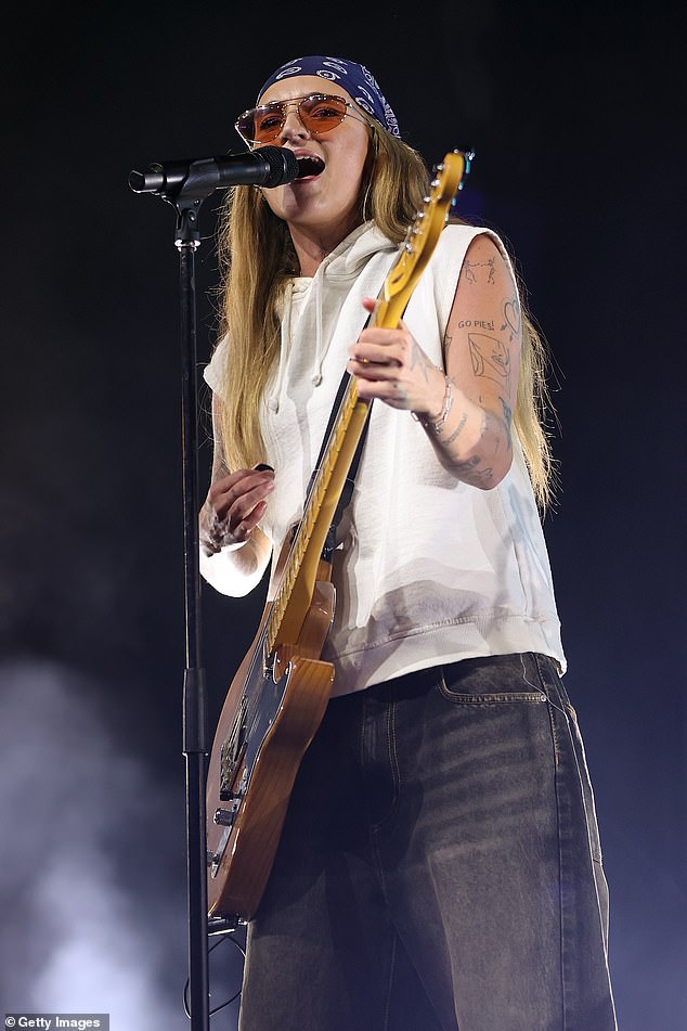Они выглядели стильно в белом свитере без рукавов и серых джинсах с широкими штанинами, демонстрируя свои навыки игры на гитаре и барабанах, распевая свои лучшие хиты.