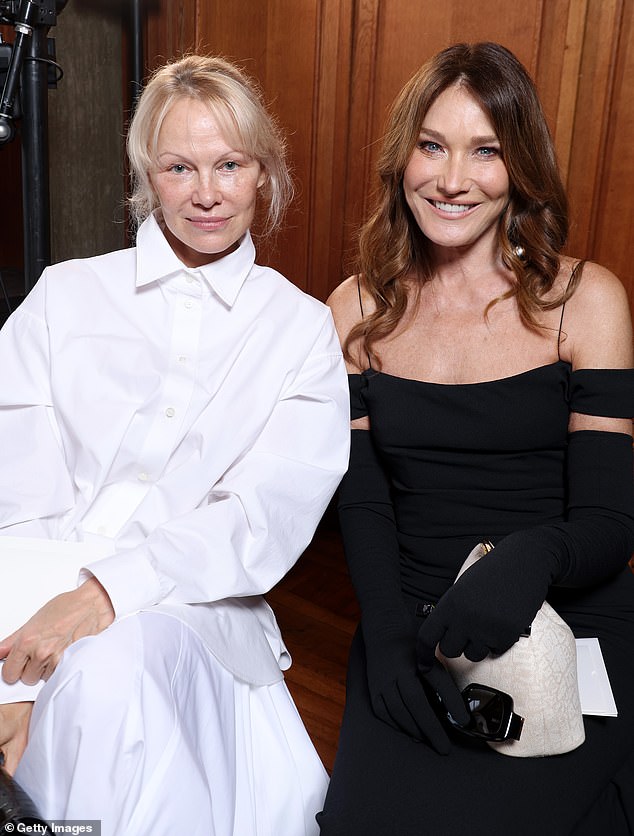 На показе Jacquemus Памела продемонстрировала шикарную фигуру в белом платье, которое она сочетала с блестящими черными туфлями на каблуках и сумкой в ​​тон (на фото с Карлой Бруни).