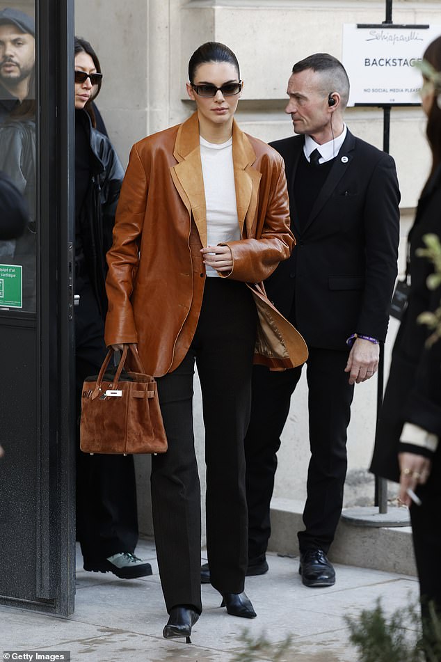 Она носила свои вещи в коричневой замшевой сумке Birkin.