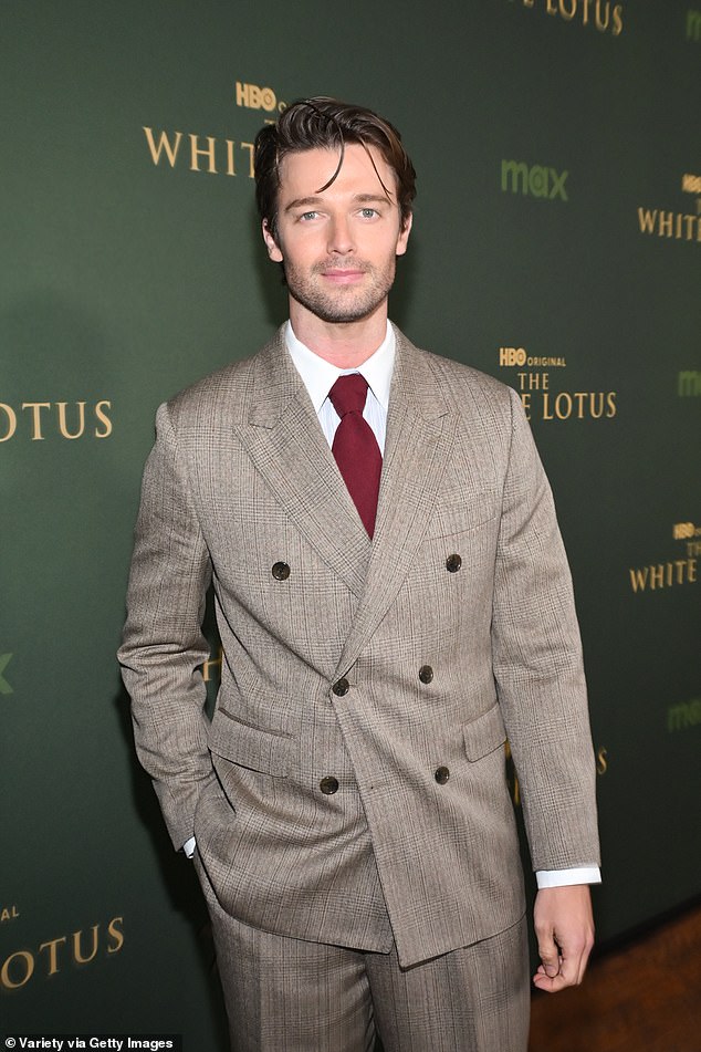 Патрик был одет в костюм с двойной грудью цвета загара, белую рубашку, бордовый галстук и блестящие черные мокасины.